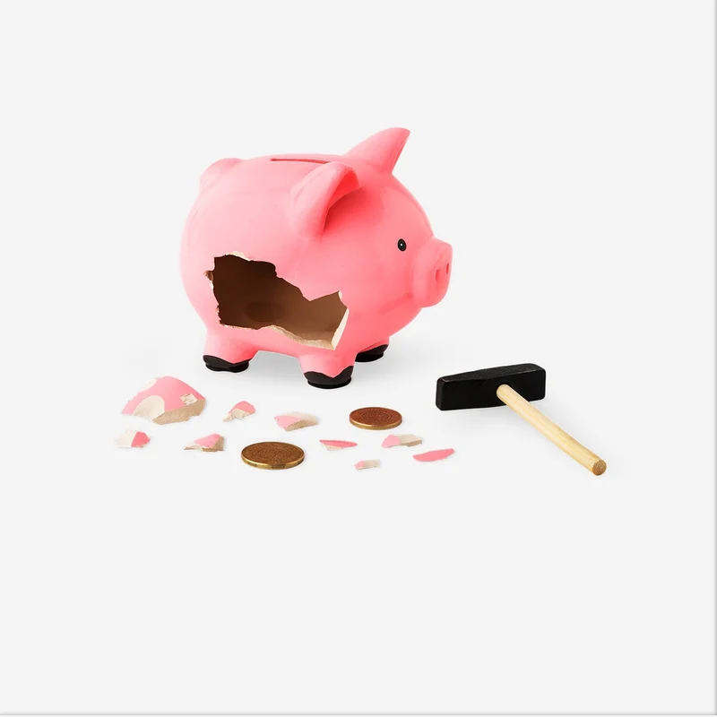 Pink piggy bank with hammer